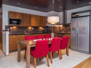 une cuisine avec une table en bois et des chaises rouges dans l'établissement Holiday Home Tahko spa suites orange a9 by Interhome, à Tahkovuori