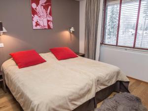 une chambre avec un lit avec deux oreillers rouges dessus dans l'établissement Holiday Home Tahko spa suites orange a 9 by Interhome, à Tahkovuori