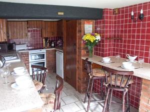 Severn Bank Lodge في Shrawley: مطبخ مع طاولة وكراسي وبلاط احمر