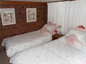 a bedroom with two beds and a brick wall at Severn Bank Lodge in Shrawley