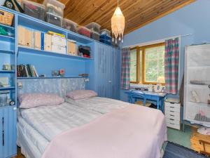 - une chambre bleue avec un lit et un bureau dans l'établissement Holiday Home Metsä-iivari by Interhome, à Piispala