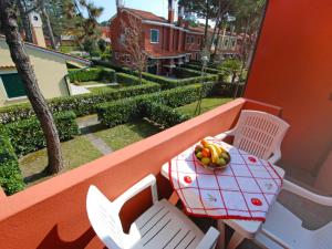 a table and chairs with a bowl of fruit on a balcony at Apartment Michelangelo-1 by Interhome in Bibione