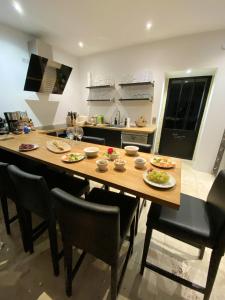 een keuken met een houten tafel met borden met eten erop bij Maison de 3 chambres avec jardin clos et wifi a Meursault in Meursault