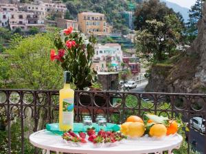 un tavolo con una bottiglia di vino e frutta sul balcone di Apartment Positano Elegant Terrace by Interhome a Positano