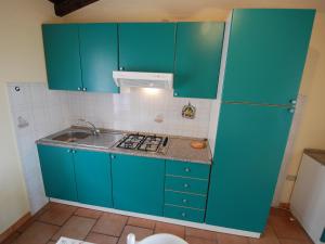 una cocina con armarios azules y fregadero en Apartment Is Murtas-4 by Interhome en Cardedu