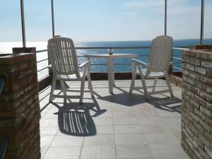 two chairs and a table on a balcony with the ocean at Apartment La Rosa-2 by Interhome in Plemmirio