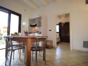 una cucina e una sala da pranzo con tavolo e sedie di Apartment La Rosa-4 by Interhome a Plemmirio