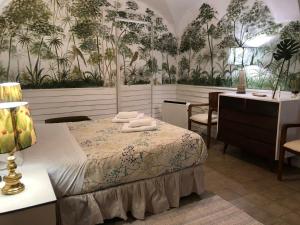een slaapkamer met een bed en een bureau met een bureau bij Apartamentos TUKASA VINTAGE in Cáceres