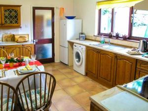 uma cozinha com uma mesa e uma máquina de lavar louça em Bryn yr Haf em Llanfair Clydogau