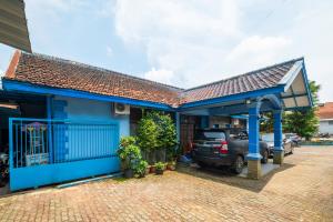 ein blaues Haus mit einem Auto in der Einfahrt in der Unterkunft RedDoorz Syariah At Jl Pangeran Hidayatullah Cianjur in Cianjur