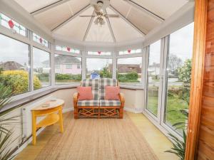 a screened in porch with a chair and a ceiling fan at Dune Haven in Truro