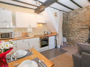 a kitchen with white cabinets and a table in a room at High View Cottage in Castleton