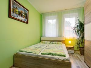 a bedroom with a bed in a green wall at Holiday Home Sunshine by Interhome in Balatonszemes +13 photos