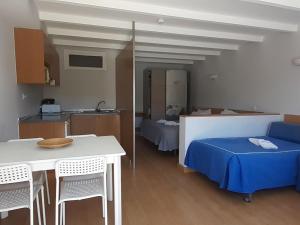 Habitación con cama azul, mesa y sillas. en Apartment Estudio by Interhome, en Sintra