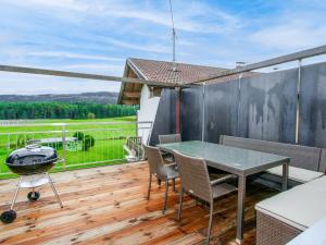 eine Terrasse mit einem Tisch, Stühlen und einem Grill in der Unterkunft Holiday Home Mitzi by Interhome in Wildermieming