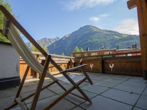 a wooden chair sitting on a balcony with a mountain at Apartment Alpin-1 by Interhome in Sölden