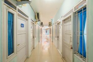 einen Korridor eines Krankenhauses mit weißen Türen und Fenstern in der Unterkunft RedDoorz Syariah At Jl Pangeran Hidayatullah Cianjur in Cianjur