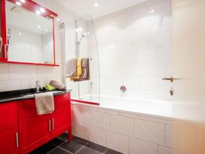 a bathroom with a red cabinet and a bath tub at Apartment Falkner-12 by Interhome in Oberlängenfeld