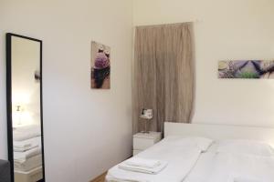 プラハにあるModern Apartment Ve Smečkách 28の白いベッドルーム(ベッド1台、鏡付)