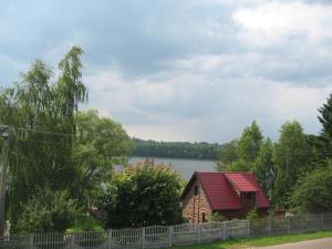 una cabaña de madera con un lago al fondo en Dom nad Jeziorem, en Rasząg