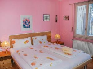 a bedroom with two beds with pink walls at Holiday Home Ursula by Interhome in Pugerna