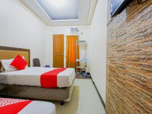 a bedroom with a bed and a brick wall at OYO 431 Apollo 11 Apartelle in Manila