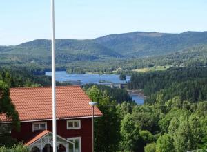 a red house with a view of a river and mountains at Guesthouse Simolle in Hammarstrand