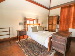 a bedroom with a bed and a table and a drawer at Cymryd Uchaf in Conwy