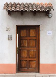 une porte en bois sur un bâtiment avec un panneau sur celui-ci dans l'établissement Chez Daniel, à Antigua Guatemala