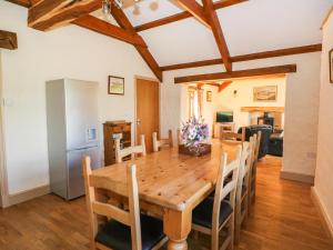 a kitchen and dining room with a wooden table and chairs at Stable Cottage in Clynderwen