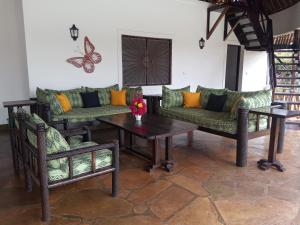 a living room with couches and a table and butterflies on the wall at Queen K Cottages Watamu At Chrystal Homes in Watamu