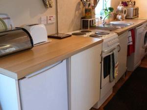 a kitchen with a counter with a stove and a sink at Riemore in Tomintoul