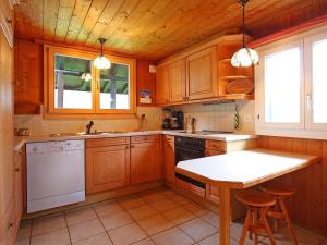 eine Küche mit Holzschränken und einem Tisch darin in der Unterkunft Chalet Egg-Isch by Interhome in Grindelwald