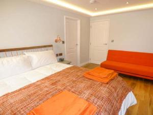 スカーバラにあるPicadoreのベッドルーム(大型ベッド1台、オレンジ色のベンチ付)
