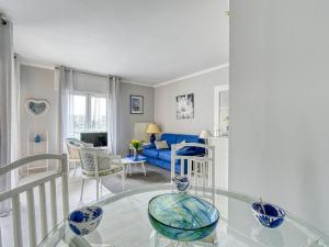 a living room with a blue couch and a glass table at Apartment Résidence Les Cariatides by Interhome in Fréjus