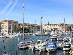 een stel boten aangemeerd in een haven met gebouwen bij Apartment Résidence Les Cariatides by Interhome in Fréjus