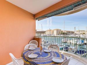 een tafel en stoelen op een balkon met een jachthaven bij Apartment Résidence Les Cariatides by Interhome in Fréjus