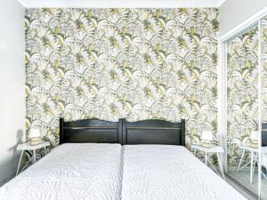 a bedroom with a bed and a wall with a wallpaper at Apartment Résidence Les Cariatides by Interhome in Fréjus