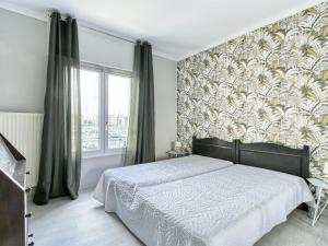 een slaapkamer met een bed en een groot raam bij Apartment Résidence Les Cariatides by Interhome in Fréjus