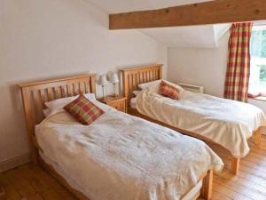 a bedroom with two beds and a window at Alpine Cottages No 4 in Reeth