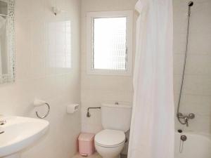 a white bathroom with a toilet and a sink at Apartment Masia Torrents 5 by Interhome in Segur de Calafell