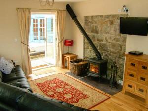 a living room with a couch and a fireplace at The Lambing Shed in Newmarket