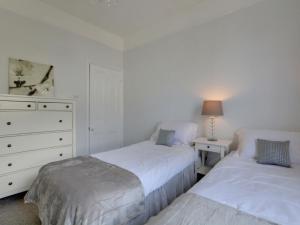 ブライトン＆ホーブにあるApartment Ivy View by Interhomeの白いベッドルーム(ベッド2台、ドレッサー付)