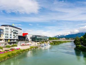 a river in a city with buildings and a bridge at Apartment smart living by Interhome in Sankt Ulrich