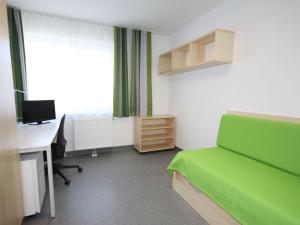 a room with a bed and a desk and a computer at Apartment smart living by Interhome in Sankt Ulrich