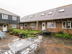 a patio with a table and chairs in front of a house at Tynk in Saint Merryn