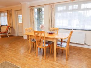 a dining room with a wooden table and chairs at Tynk in Saint Merryn +8 photos