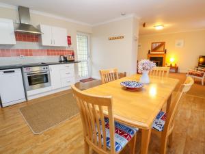 a kitchen and dining room with a wooden table at Tynk in St Merryn