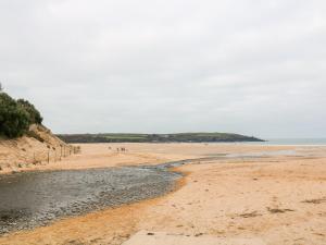 a beach with people walking on the sand at Tynk in Saint Merryn