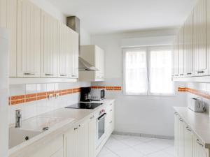 a white kitchen with white cabinets and a sink at Apartment Résidence L'Amiral by Interhome in Saint-Raphaël